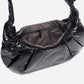 A black shiny Croissant-shaped shoulder bag with a single strap in polish black color