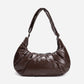 A dark brown shiny Croissant-shaped shoulder bag in polish brown color by Dude & Bestie