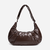A dark brown shiny Croissant-shaped shoulder bag in polish brown color by Dude & Bestie