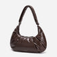 A dark brown shiny Croissant-shaped shoulder bag in polish brown color by Dude & Bestie