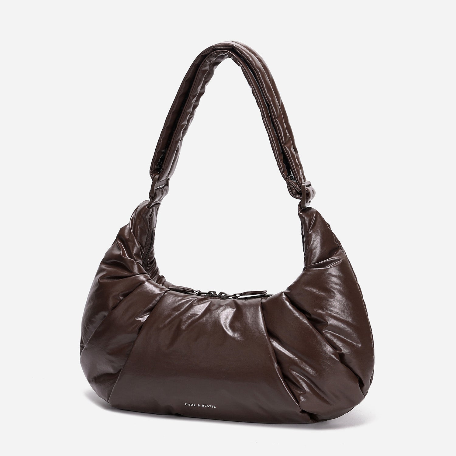 A dark brown shiny Croissant-shaped shoulder bag in polish brown color by Dude & Bestie