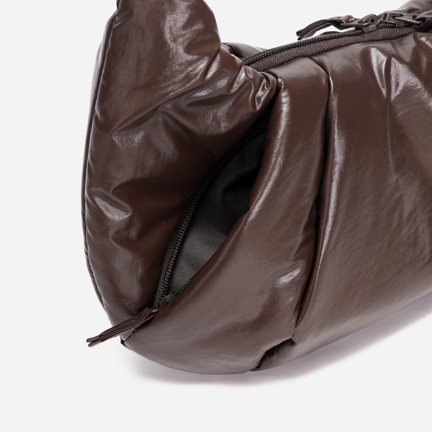 A dark brown shiny Croissant-shaped shoulder bag in polish brown color by Dude & Bestie