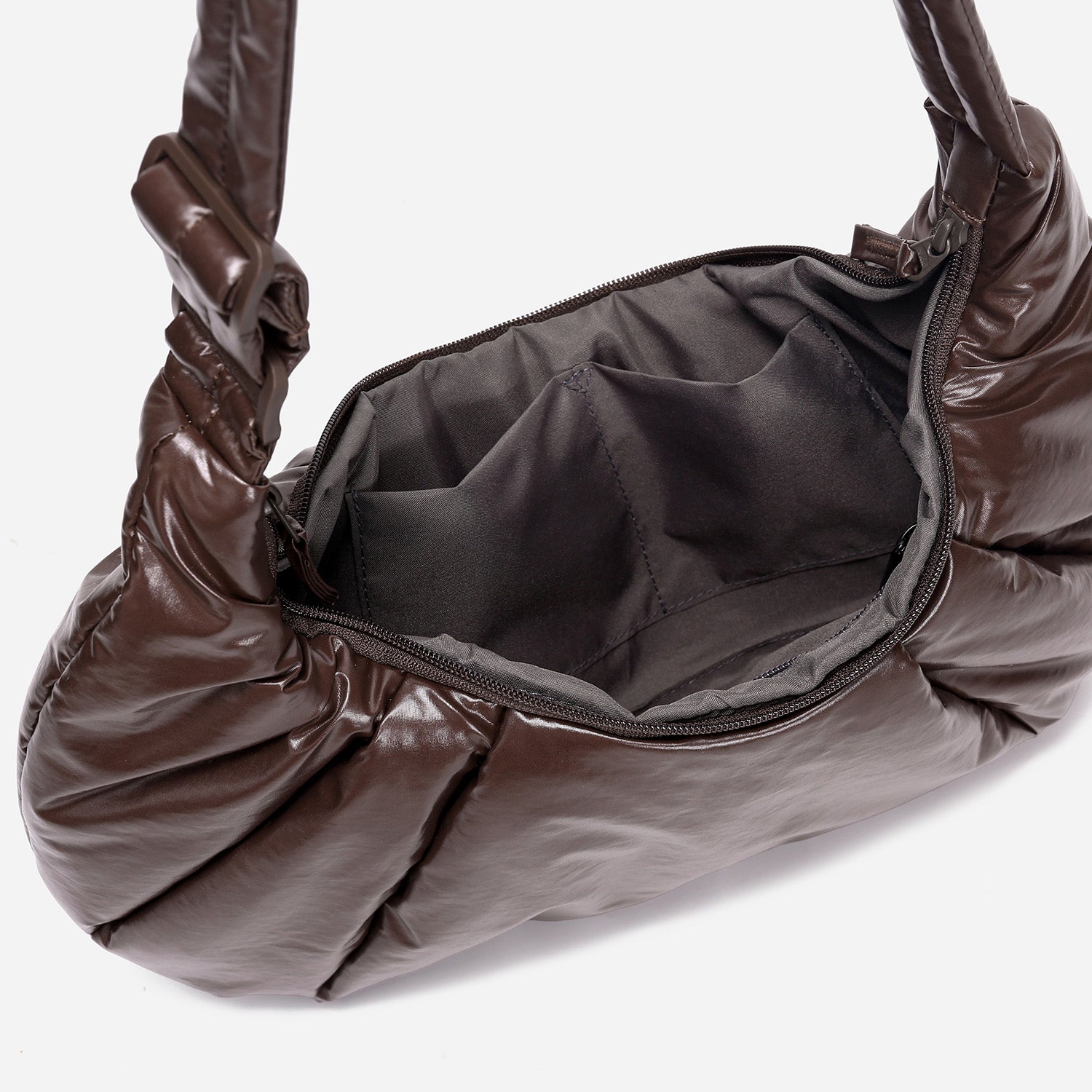 A dark brown shiny Croissant-shaped shoulder bag in polish brown color by Dude & Bestie