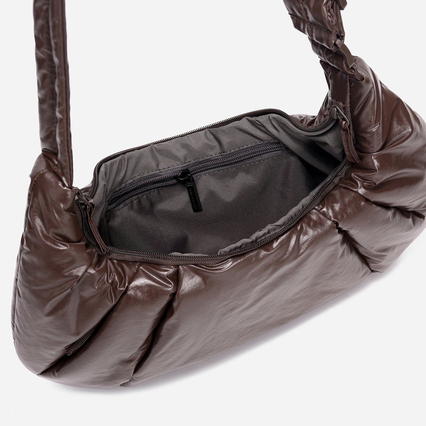 A dark brown shiny Croissant-shaped shoulder bag in polish brown color by Dude & Bestie
